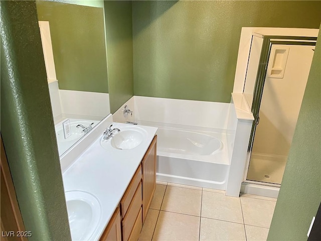 full bath featuring a garden tub, tile patterned flooring, a sink, a shower stall, and double vanity