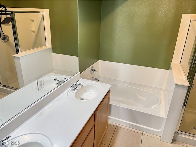 bathroom featuring a garden tub, tile patterned flooring, and a sink