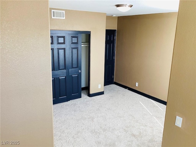 unfurnished bedroom featuring baseboards, visible vents, and light colored carpet