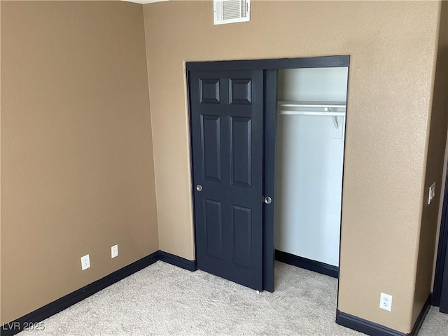 unfurnished bedroom featuring baseboards, visible vents, and light colored carpet