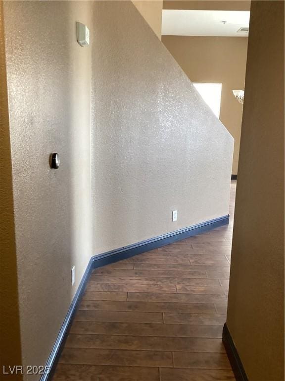 corridor with dark wood finished floors and baseboards