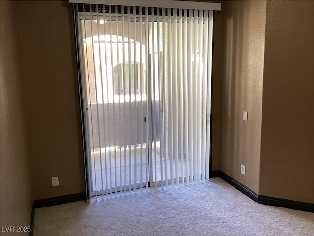 unfurnished room featuring baseboards and light colored carpet