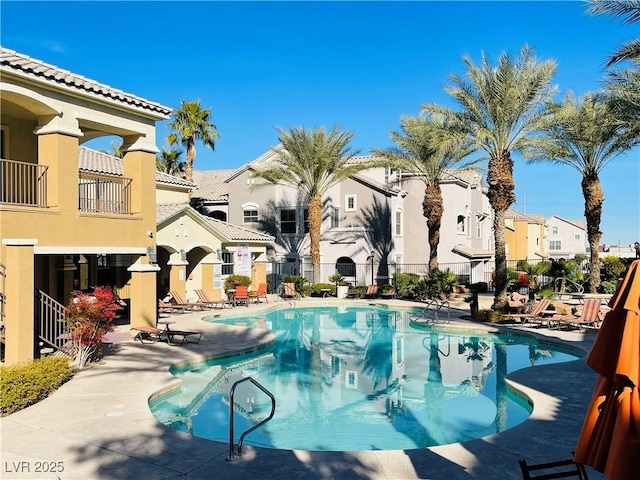 pool featuring a residential view, a patio area, and fence