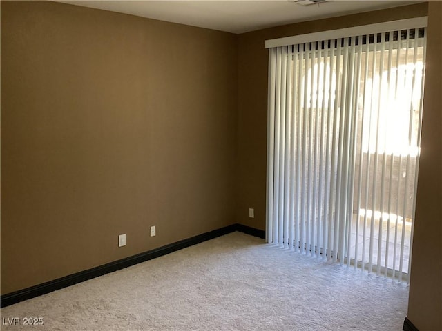 carpeted spare room featuring visible vents and baseboards