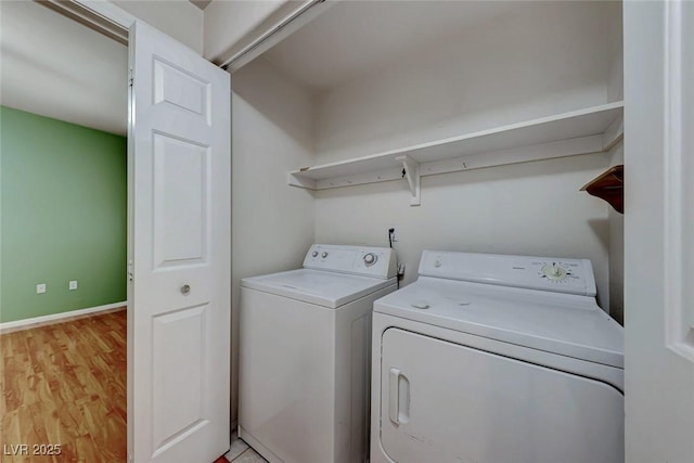 washroom with laundry area, baseboards, light wood-style floors, and independent washer and dryer