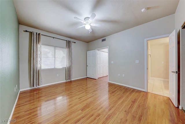 unfurnished bedroom with baseboards, visible vents, and light wood-style floors