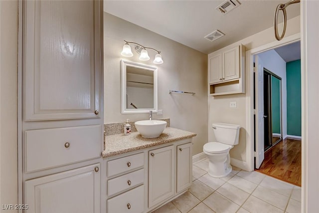 bathroom featuring toilet, vanity, tile patterned flooring, and visible vents