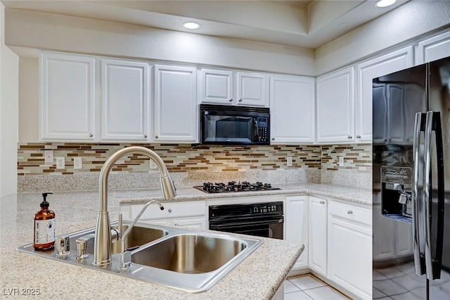 kitchen with black appliances, white cabinetry, and light countertops