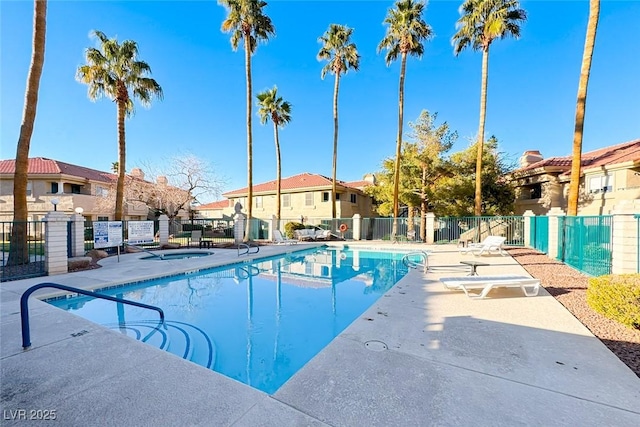 community pool featuring a hot tub, a residential view, fence, and a patio