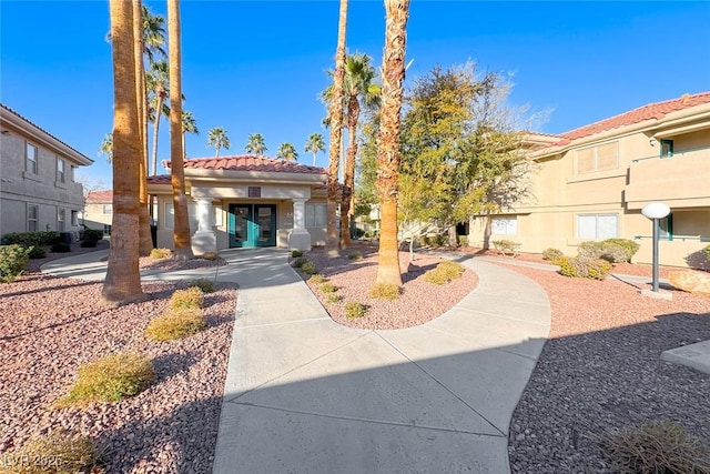 exterior space with a tile roof and stucco siding