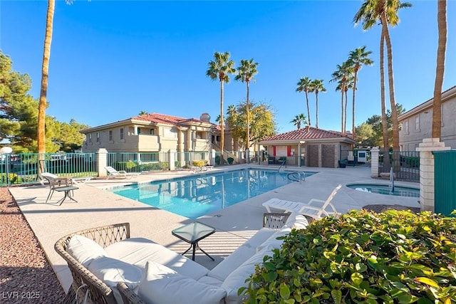 community pool featuring a patio and fence