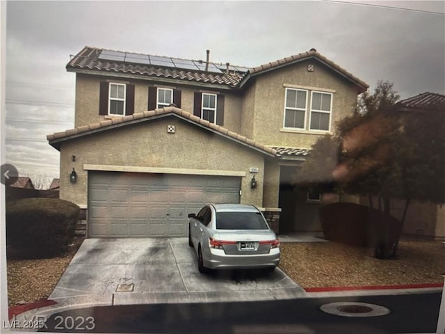 view of front of home with a garage, solar panels, a tile roof, driveway, and stucco siding