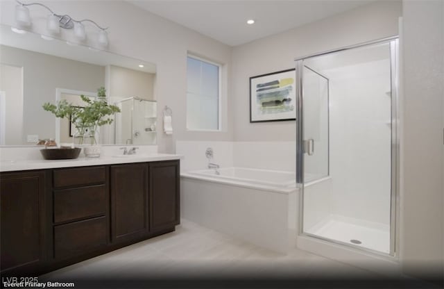 bathroom featuring a stall shower, vanity, a bath, and recessed lighting