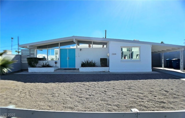 view of front of home featuring an attached carport and stucco siding