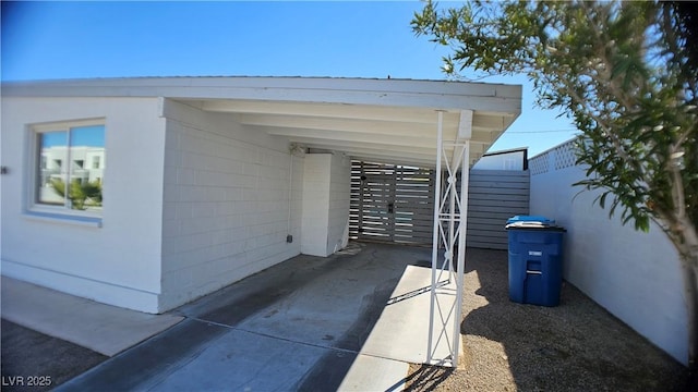 view of parking / parking lot featuring a carport and fence