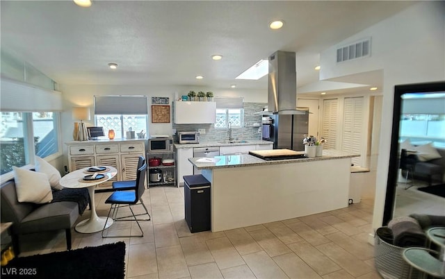 kitchen with tasteful backsplash, visible vents, appliances with stainless steel finishes, island exhaust hood, and a sink