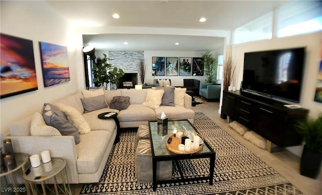 living room featuring recessed lighting and a stone fireplace