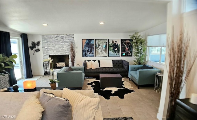 living room featuring recessed lighting and a stone fireplace