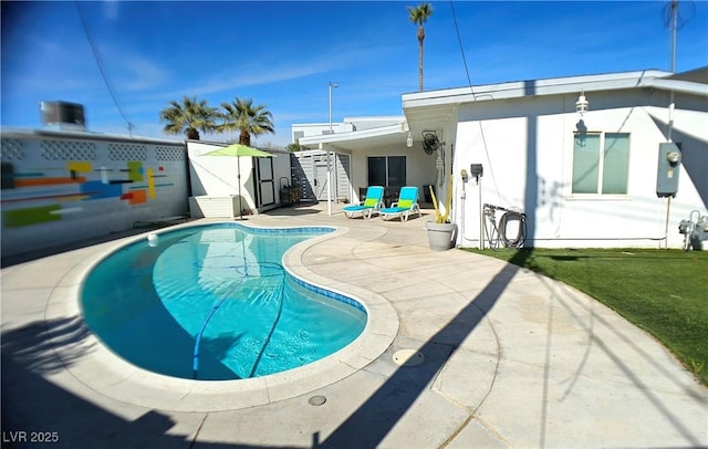 back of property with a fenced in pool, an outbuilding, a patio area, and a shed