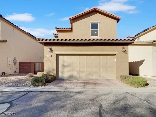 mediterranean / spanish-style home with fence, decorative driveway, and stucco siding