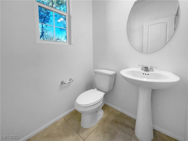 half bath featuring toilet, baseboards, and tile patterned floors