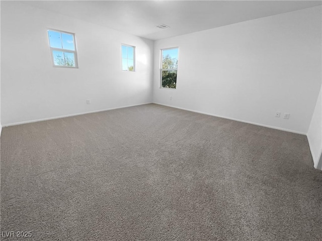 carpeted empty room featuring visible vents and baseboards