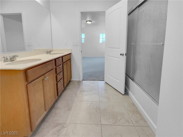 full bath with double vanity, tile patterned flooring, combined bath / shower with glass door, and a sink