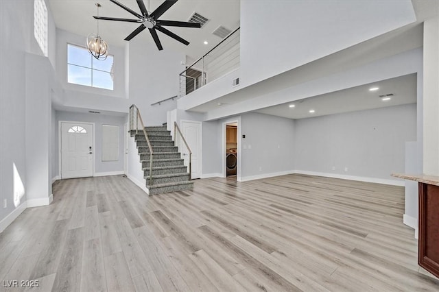 entrance foyer with light wood-style floors, visible vents, baseboards, and stairs