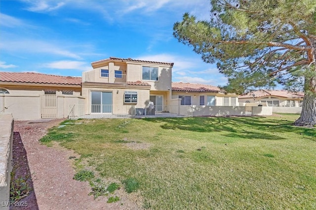 rear view of property featuring a yard, fence private yard, and stucco siding