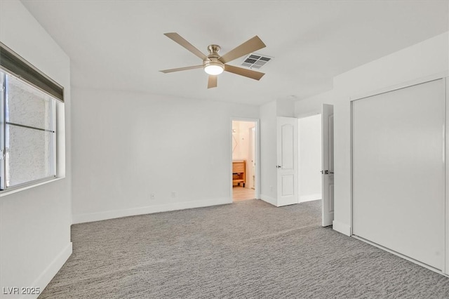 unfurnished bedroom with ensuite bathroom, carpet floors, visible vents, baseboards, and a closet