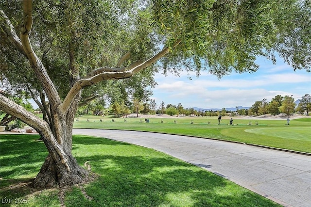 surrounding community featuring golf course view and a yard