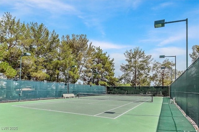 view of tennis court featuring fence