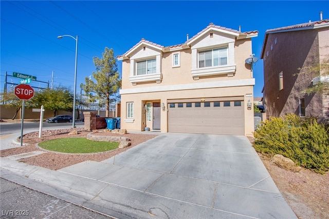 traditional home featuring concrete driveway, an attached garage, a tile roof, and stucco siding