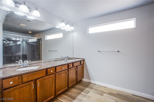 bathroom with a wealth of natural light, a sink, a shower stall, and double vanity