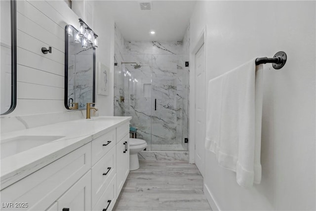 bathroom featuring double vanity, a marble finish shower, visible vents, toilet, and a sink