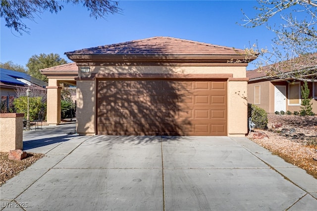 view of front of home featuring concrete driveway, a tiled roof, and stucco siding