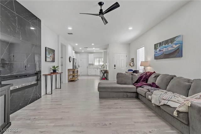 living room featuring light wood-style floors, recessed lighting, visible vents, and ceiling fan