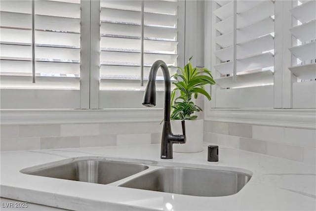 room details with a sink and light stone countertops