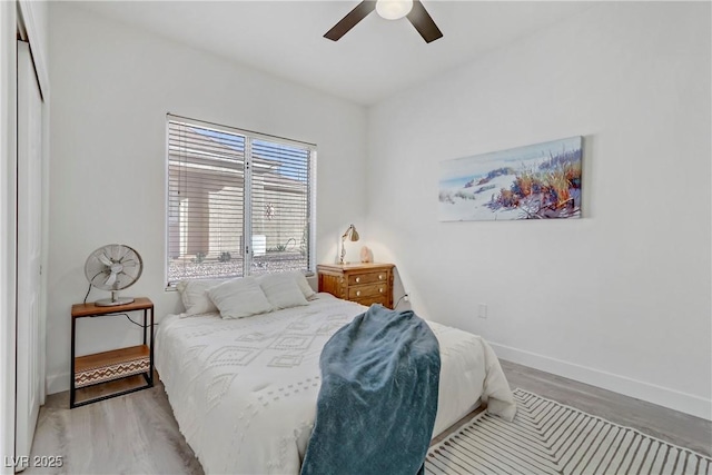 bedroom featuring baseboards, ceiling fan, and light wood-style floors