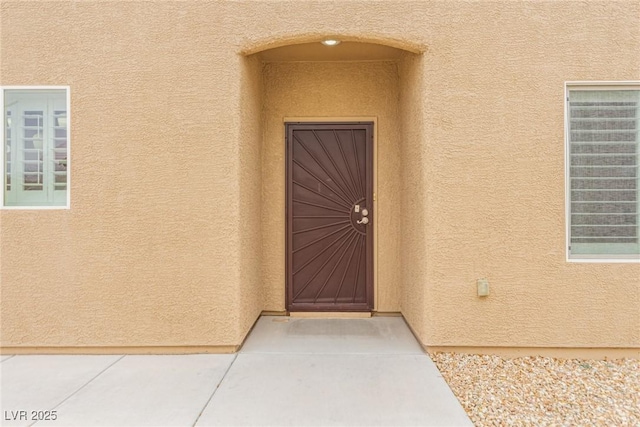 property entrance featuring stucco siding