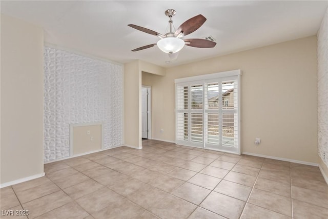 empty room with visible vents, light tile patterned flooring, a ceiling fan, and baseboards