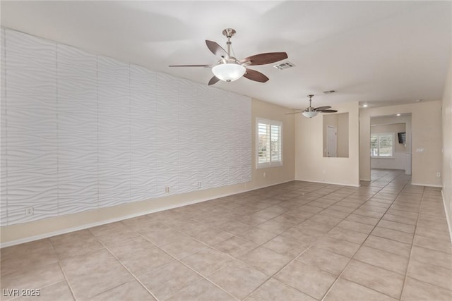 empty room with light tile patterned flooring, visible vents, and a ceiling fan