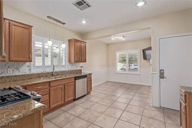 kitchen with brown cabinetry, visible vents, appliances with stainless steel finishes, and a sink