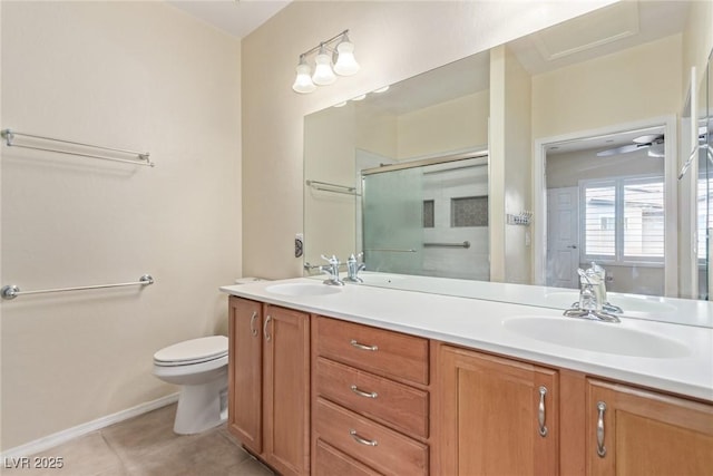 bathroom featuring toilet, double vanity, a stall shower, tile patterned floors, and a sink