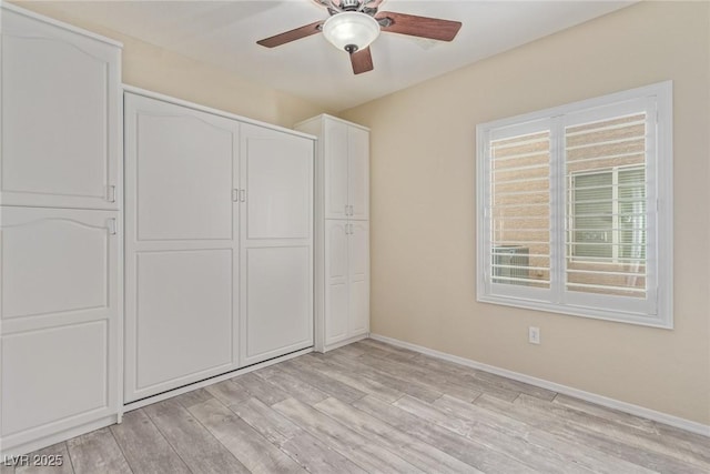 unfurnished bedroom with ceiling fan, a closet, baseboards, and light wood-style flooring