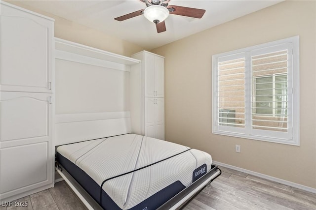 bedroom featuring a closet, ceiling fan, baseboards, and light wood-style floors