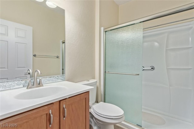 full bathroom with vanity, toilet, and a stall shower