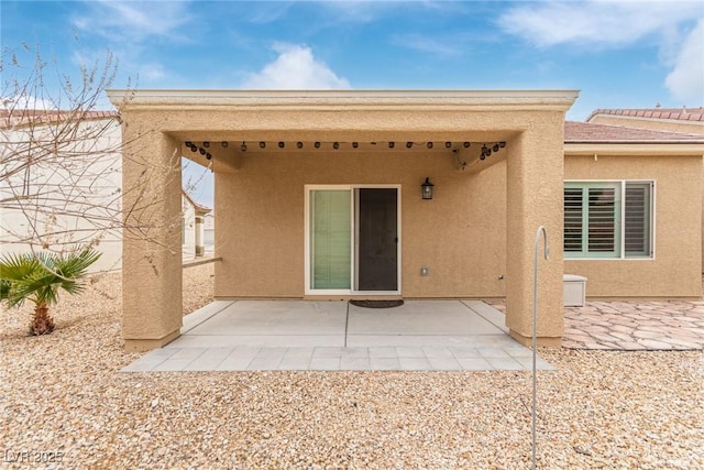 rear view of property featuring a patio area and stucco siding