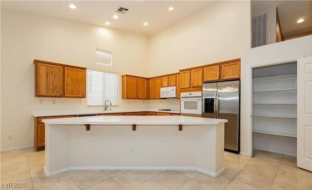 kitchen with light countertops, white appliances, and a center island