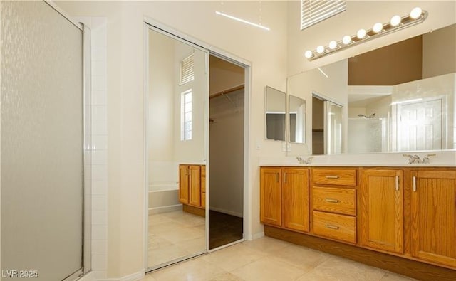 full bathroom featuring tile patterned flooring, a sink, a shower stall, a bath, and double vanity